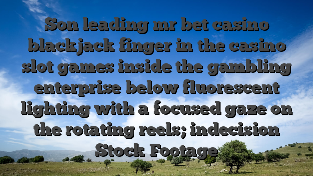 Son leading mr bet casino blackjack finger in the casino slot games inside the gambling enterprise below fluorescent lighting with a focused gaze on the rotating reels; indecision Stock Footage